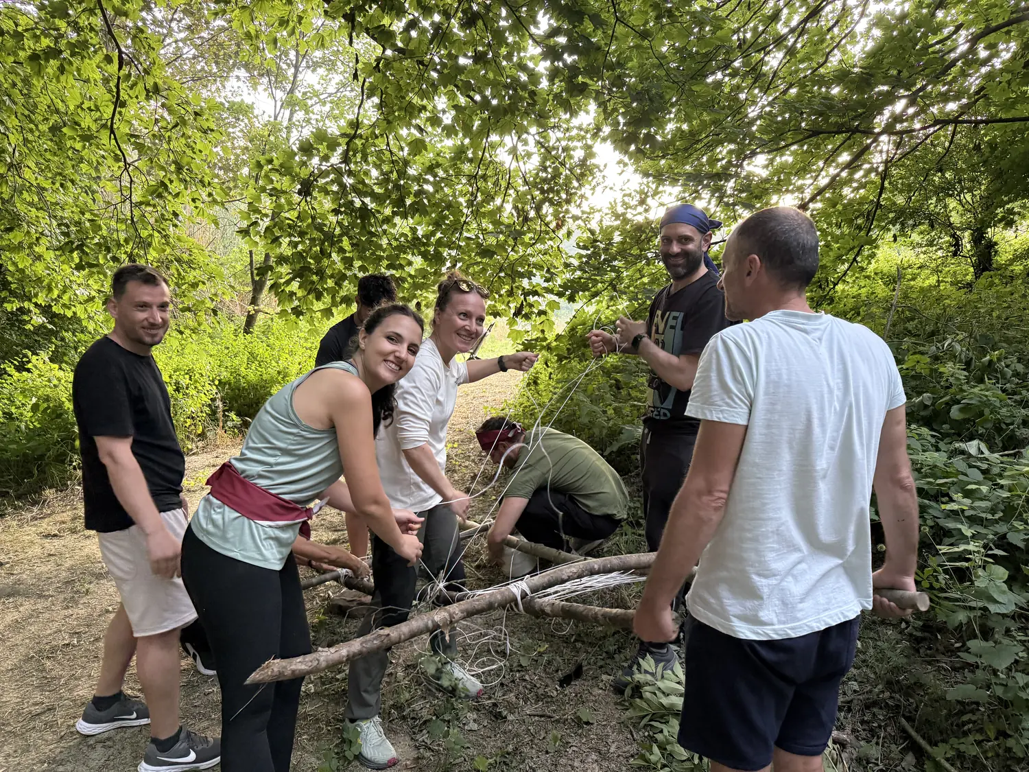 Team aziendale che costruisce una struttura di legno durante un team building BOSCO PRO