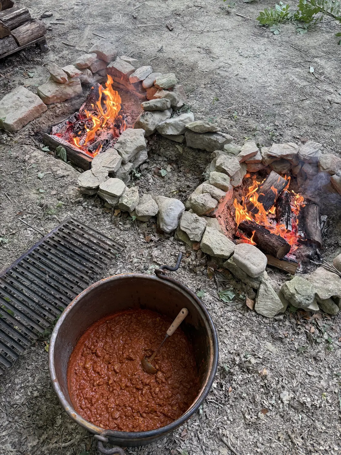 Pentola che cuoce sul fuoco da campo durante un team building BOSCO PRO